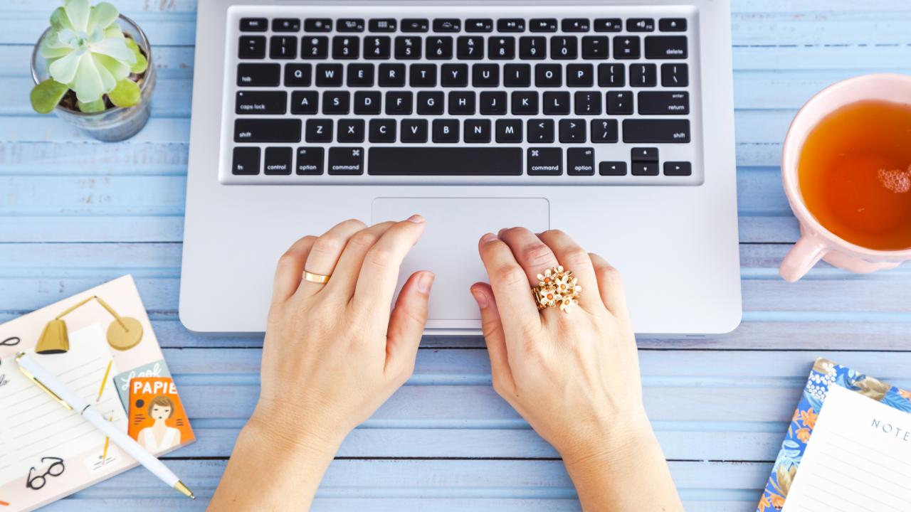 Woman's hands typing on laptop.