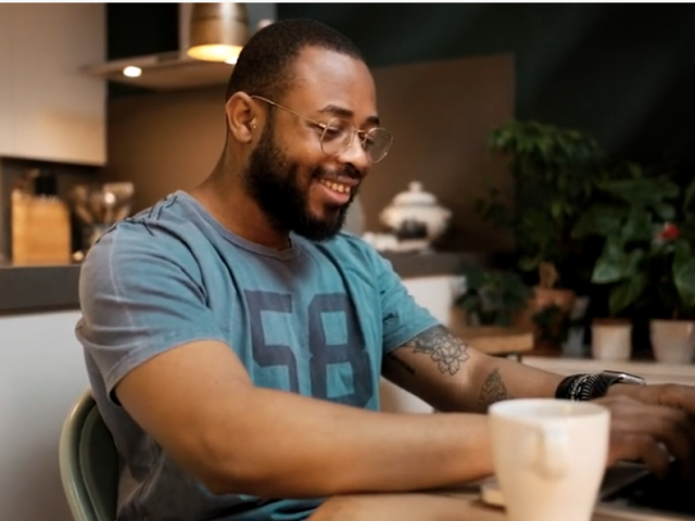 Man using a laptop at his kitchen table.