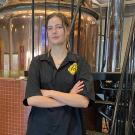 Master Brewer grad Ava Kemper poses in Sudwerk Brewing Company's brewer