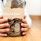 glass jar with money and education sign on it